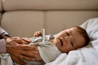 Poorly baby lying down and having their temperature taken