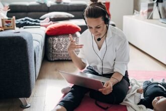 woman works on laptop sitting on living room floor - work life balance