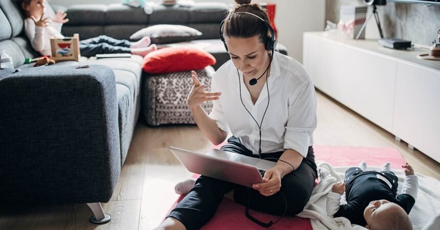 woman works on laptop sitting on living room floor - work life balance
