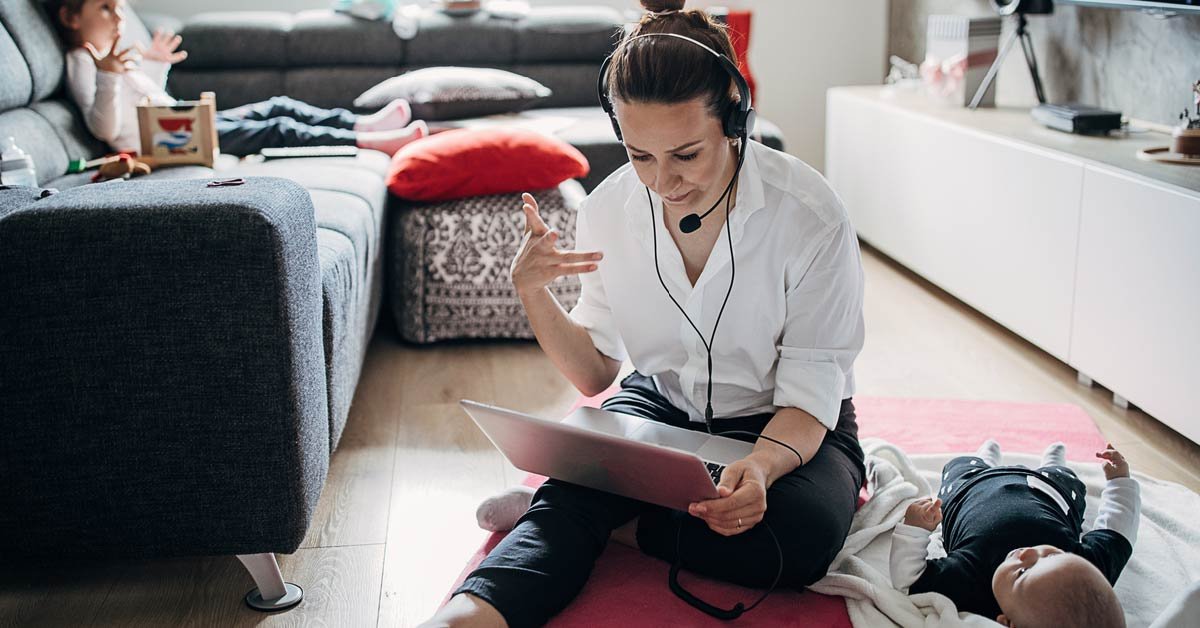 woman works on laptop sitting on living room floor - work life balance